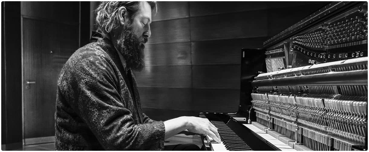 A man playing Steinway upright piano.